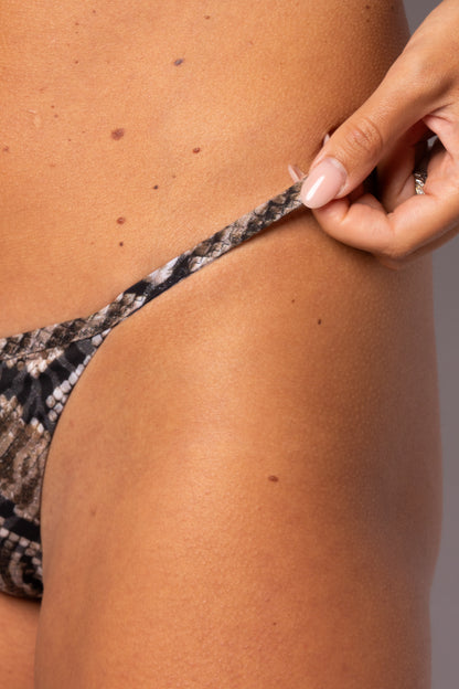 Dettaglio laterale slip bikini Rosale con stampa pitonata neutra e laccetto sottile