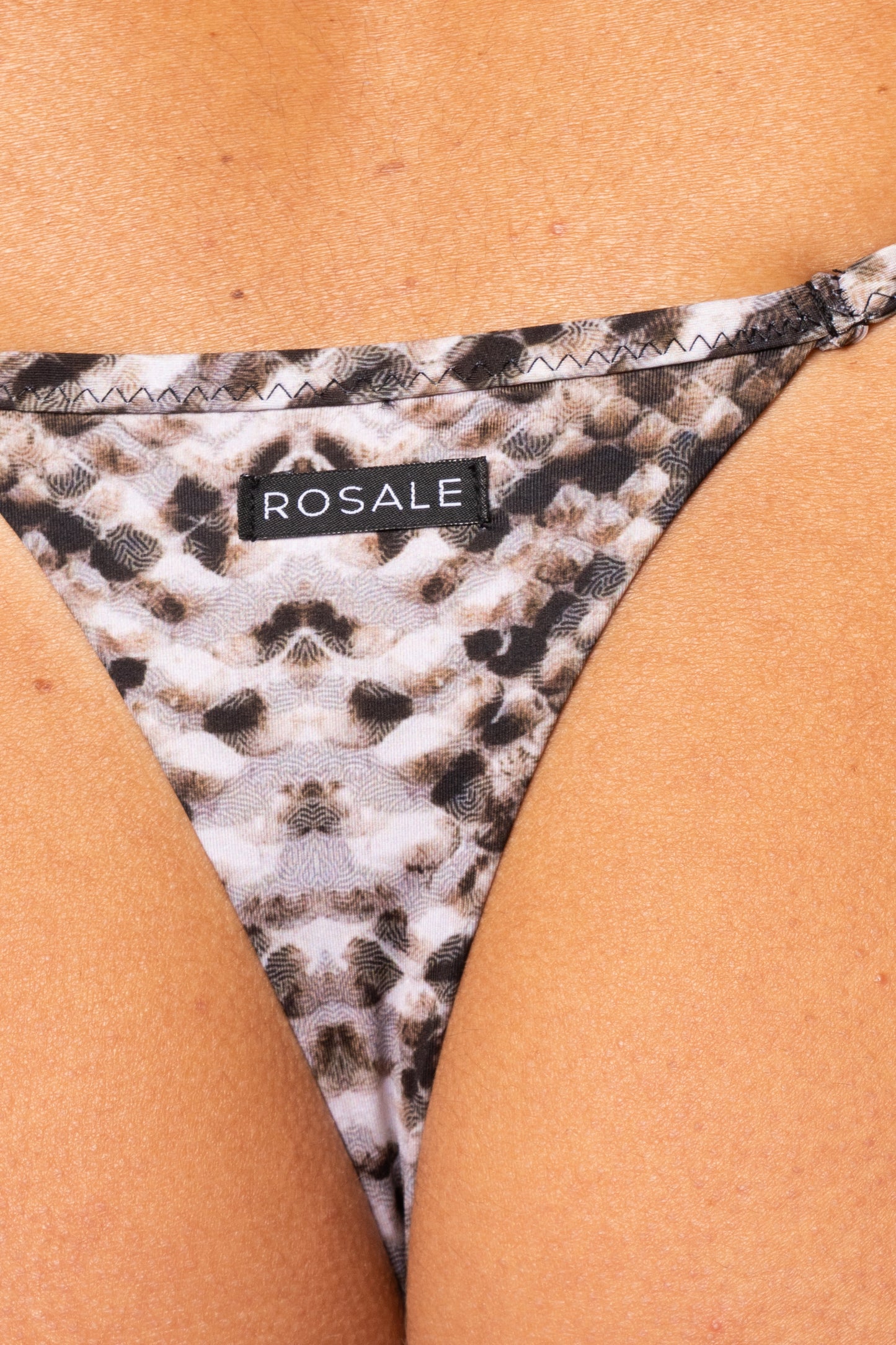 Dettaglio del retro dello slip con stampa pitonata neutra con etichetta del logo Rosale cucita sul tessuto 