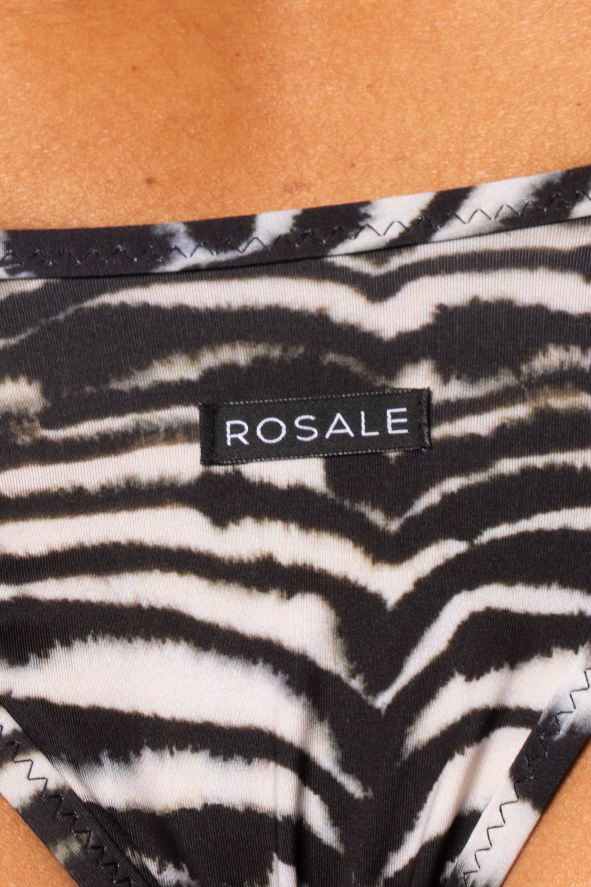 Dettaglio del retro dello slip con stampa zebra bianco e nero con etichetta nera del logo Rosale cucita sul tessuto 